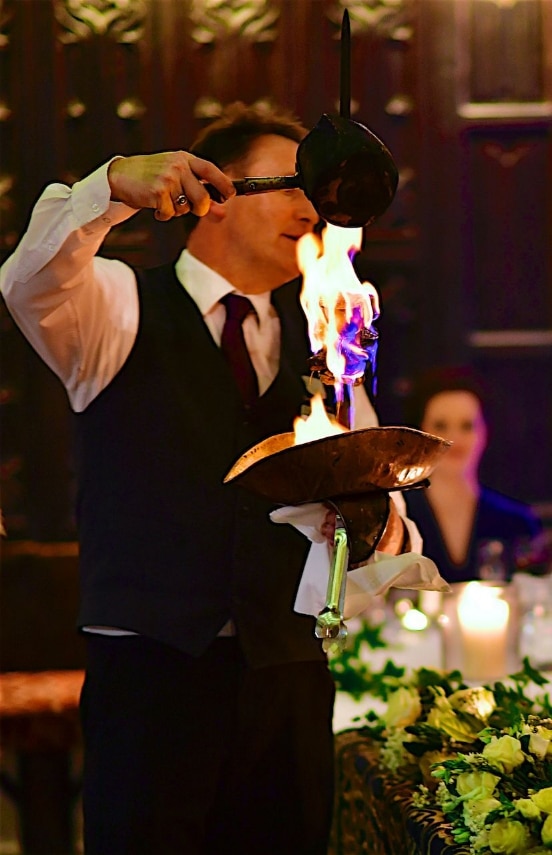 The Drunken Bullock steak being flambéed on a sword in the Banqueting Hall.